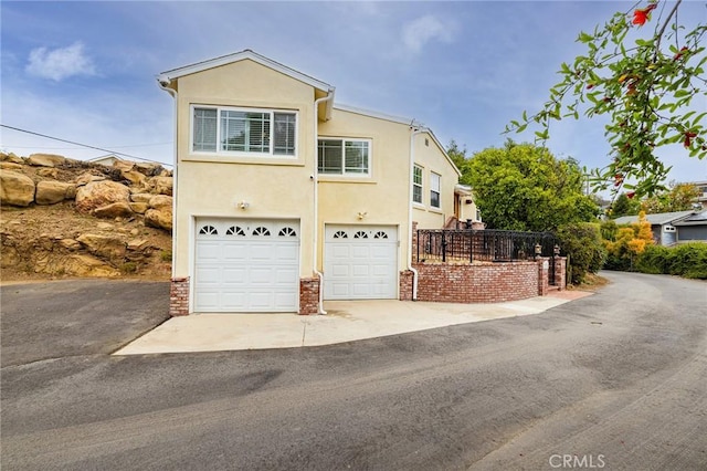 view of front of home with an attached garage, stucco siding, and driveway