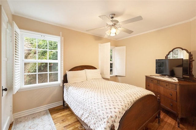 bedroom featuring wood finished floors, baseboards, ornamental molding, and ceiling fan