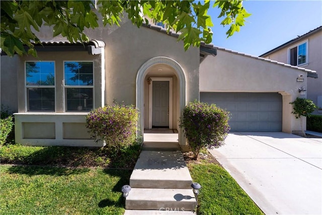 3225 E Denali Dr, Ontario, CA 91762 - view of front facade featuring stucco siding, a garage, and concrete driveway