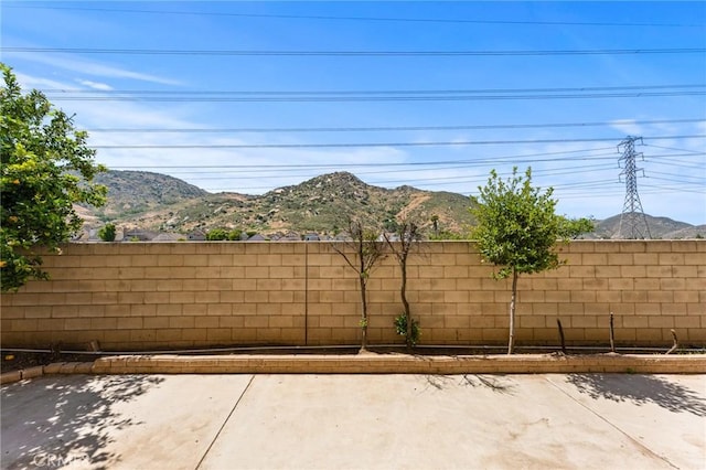 16129 Windcrest Dr, Fontana, CA 92337 - view of patio featuring fence and a mountain view
