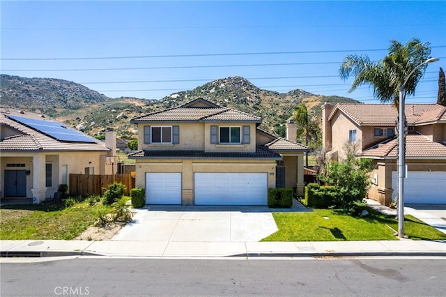 16129 Windcrest Dr, Fontana, CA 92337 - view of front of home featuring stucco siding, a chimney, a mountain view, and concrete driveway