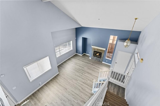 16129 Windcrest Dr, Fontana, CA 92337 - unfurnished living room featuring wood finished floors, high vaulted ceiling, baseboards, and a fireplace