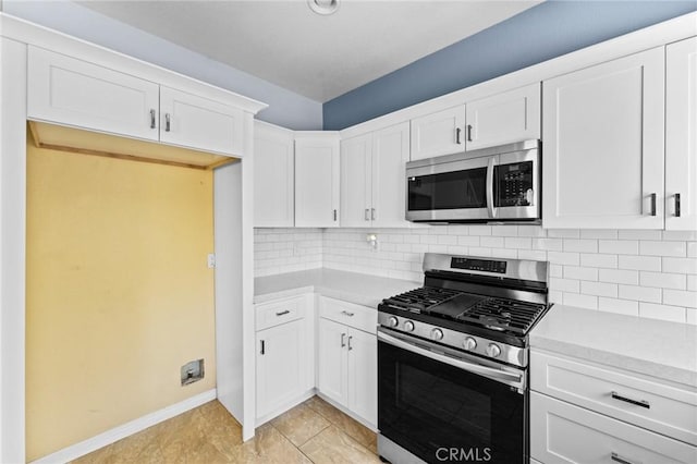 16129 Windcrest Dr, Fontana, CA 92337 - kitchen with appliances with stainless steel finishes, light countertops, tasteful backsplash, white cabinets, and baseboards