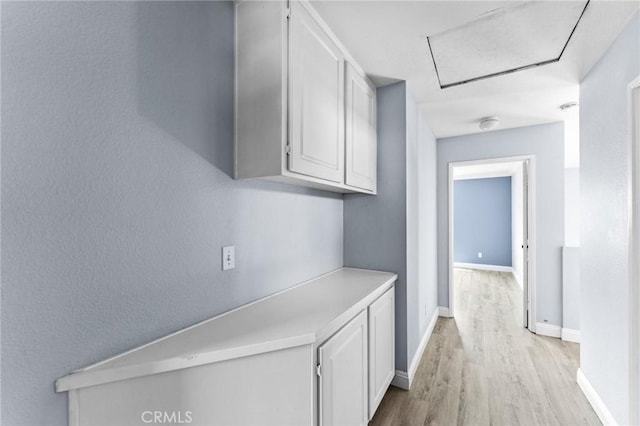 16129 Windcrest Dr, Fontana, CA 92337 - hall with light wood-type flooring, attic access, and baseboards