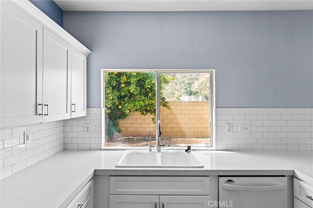 16129 Windcrest Dr, Fontana, CA 92337 - kitchen featuring stainless steel dishwasher, a sink, light countertops, white cabinetry, and tasteful backsplash