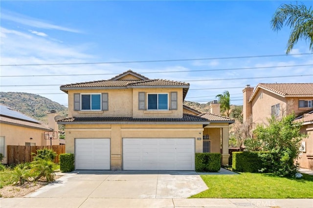 16129 Windcrest Dr, Fontana, CA 92337 - traditional home featuring a tile roof, stucco siding, an attached garage, and driveway