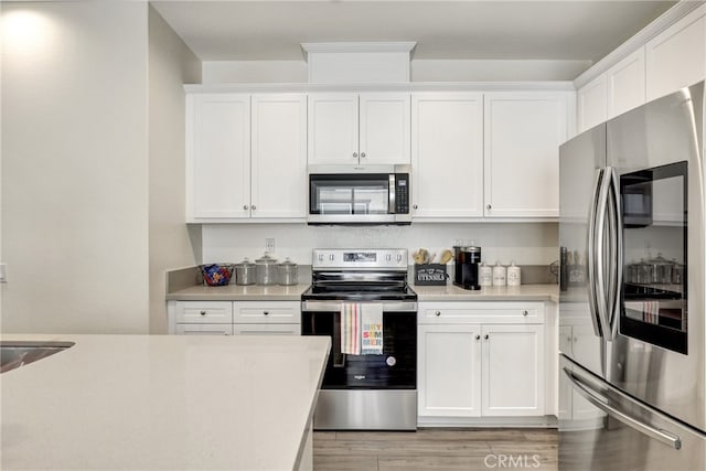 7354 Freesia Ln, Chino, CA 91708 - kitchen with stainless steel appliances, light countertops, white cabinetry, and light wood-style flooring