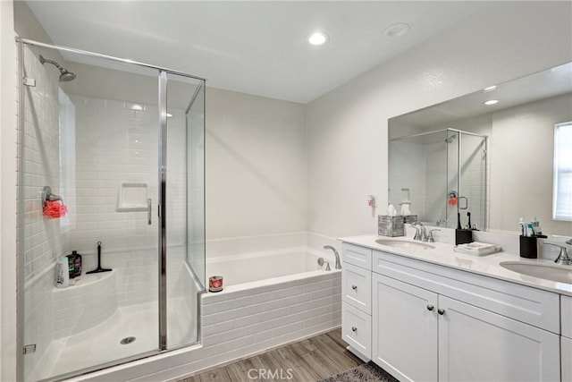 7354 Freesia Ln, Chino, CA 91708 - full bath featuring wood finished floors, a shower stall, a garden tub, double vanity, and recessed lighting