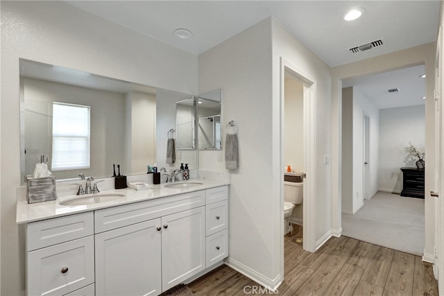 7354 Freesia Ln, Chino, CA 91708 - bathroom with wood finished floors, toilet, double vanity, baseboards, and recessed lighting