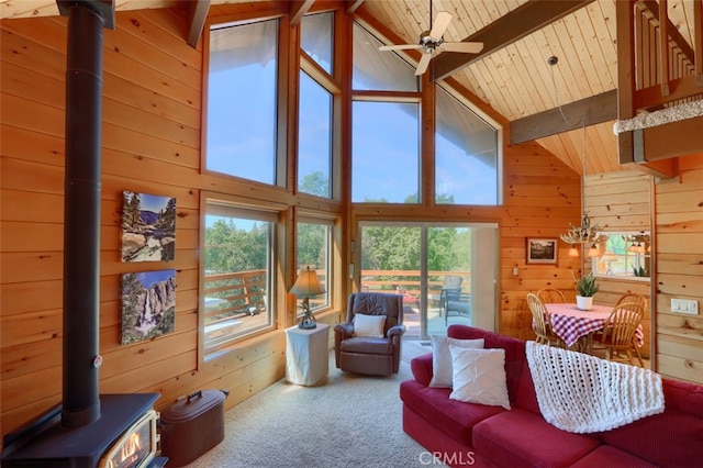 5027 Fox Creek Rd, Mariposa, CA 95338 - living room featuring a wood stove, wooden walls, carpet, healthy amount of natural light, and high vaulted ceiling