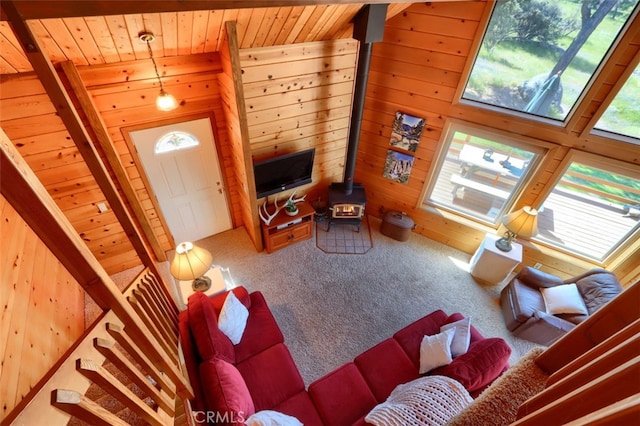5027 Fox Creek Rd, Mariposa, CA 95338 - living area featuring a wood stove, wood ceiling, wooden walls, carpet flooring, and stairs