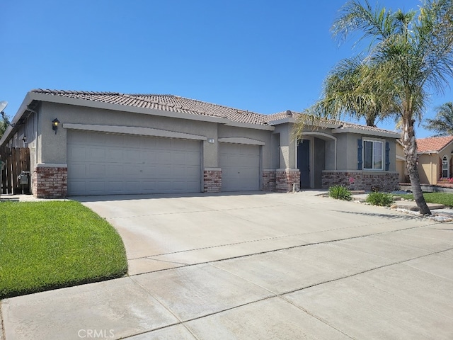 511 Milano Ct, Los Banos, CA 93635 - view of front of house with an attached garage, stucco siding, concrete driveway, a tiled roof, and stone siding