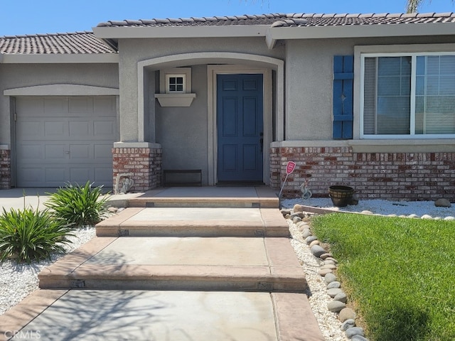 511 Milano Ct, Los Banos, CA 93635 - doorway to property featuring stucco siding, an attached garage, and a tile roof