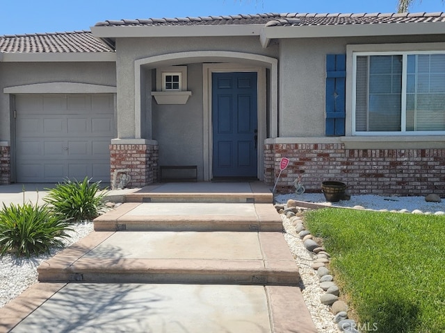 511 Milano Ct, Los Banos, CA 93635 - entrance to property with stucco siding, an attached garage, a tile roof, and stone siding