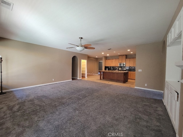 511 Milano Ct, Los Banos, CA 93635 - unfurnished living room with arched walkways, recessed lighting, baseboards, a ceiling fan, and light colored carpet