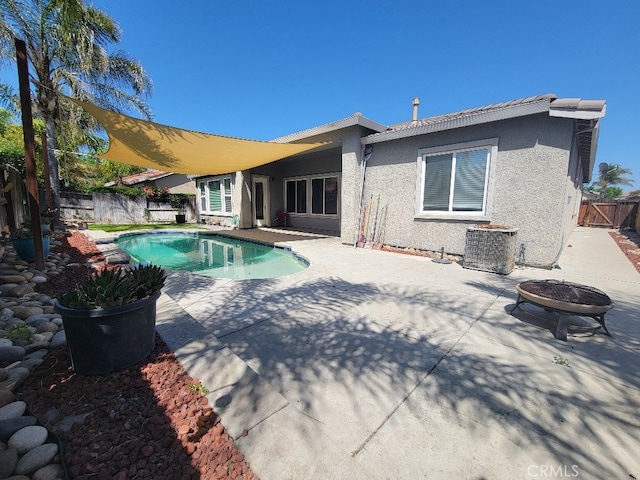511 Milano Ct, Los Banos, CA 93635 - back of property featuring an outdoor fire pit, a patio, stucco siding, and a fenced backyard