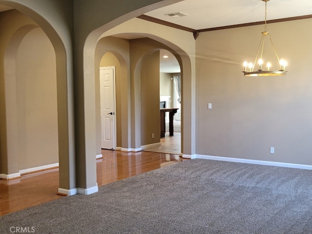 511 Milano Ct, Los Banos, CA 93635 - unfurnished room featuring carpet flooring, crown molding, a chandelier, and wood finished floors