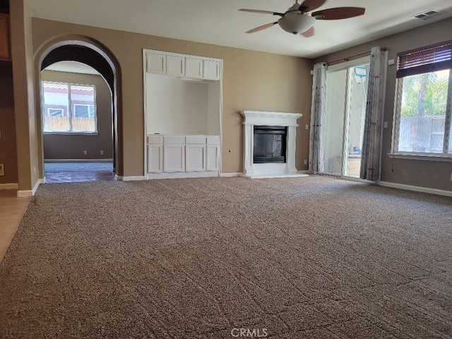 511 Milano Ct, Los Banos, CA 93635 - unfurnished living room with a ceiling fan, carpet floors, healthy amount of natural light, and a glass covered fireplace