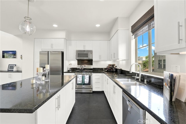 7 Abarrota St, Rancho Mission Viejo, CA 92694 - kitchen featuring stainless steel appliances, a sink, white cabinetry, pendant lighting, and dark stone counters