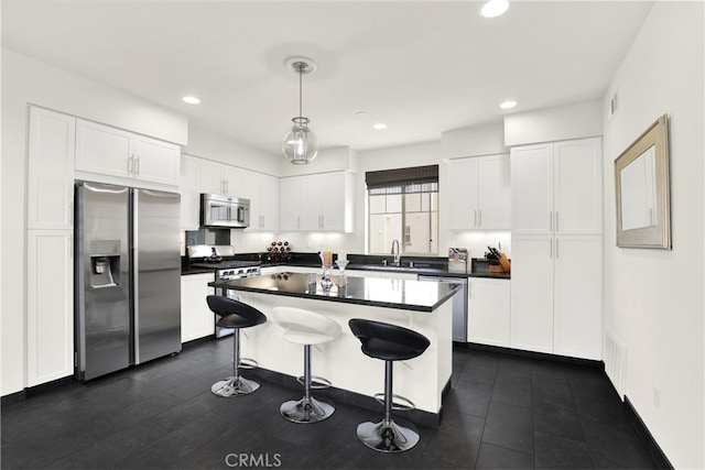 7 Abarrota St, Rancho Mission Viejo, CA 92694 - kitchen featuring stainless steel appliances, a sink, dark countertops, white cabinets, and a kitchen island