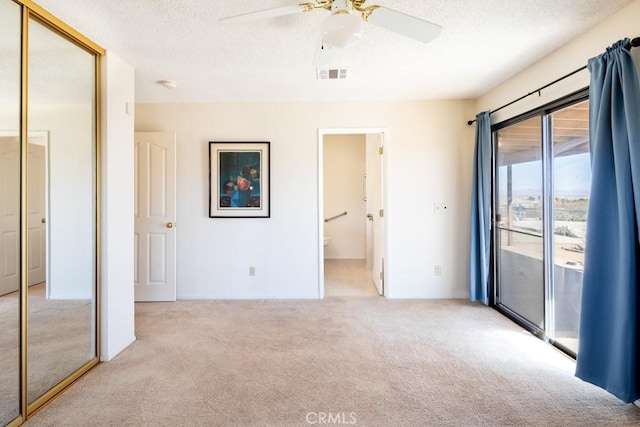 6425 Indian Cove Rd Unit 29, Palms, CA 92277 - unfurnished bedroom with carpet, access to outside, a closet, a textured ceiling, and ensuite bath