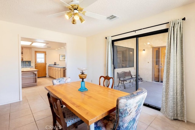 6425 Indian Cove Rd Unit 29, Palms, CA 92277 - dining area with light tile patterned floors, a ceiling fan, and a textured ceiling