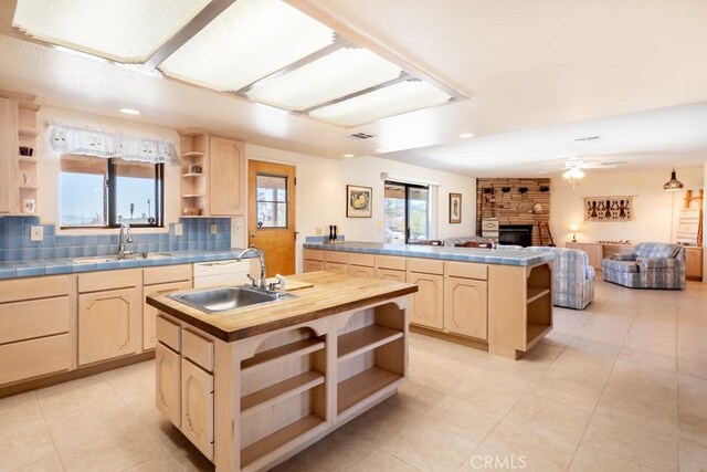 6425 Indian Cove Rd Unit 29, Palms, CA 92277 - kitchen featuring open shelves, light brown cabinetry, a sink, a fireplace, and recessed lighting