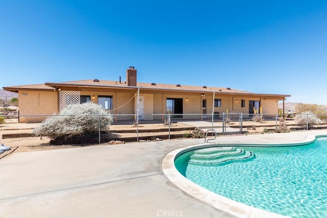 6425 Indian Cove Rd Unit 29, Palms, CA 92277 - back of house with a patio area, stucco siding, and a chimney