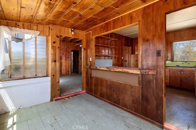 6425 Indian Cove Rd Unit 29, Palms, CA 92277 - kitchen featuring wood walls, wooden ceiling, a sink, and brown cabinets