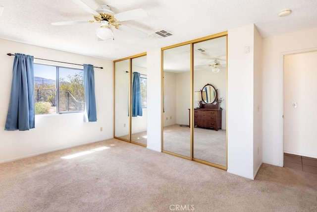 6425 Indian Cove Rd Unit 29, Palms, CA 92277 - unfurnished bedroom with two closets, carpet flooring, and ceiling fan