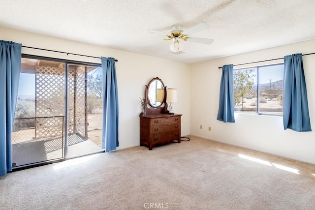 6425 Indian Cove Rd Unit 29, Palms, CA 92277 - bedroom featuring carpet flooring, access to exterior, ceiling fan, and a textured ceiling