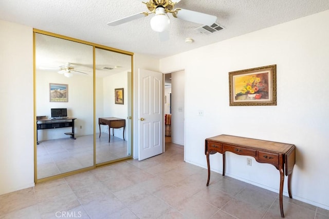 6425 Indian Cove Rd Unit 29, Palms, CA 92277 - bedroom with a textured ceiling, a closet, a ceiling fan, and light tile patterned floors