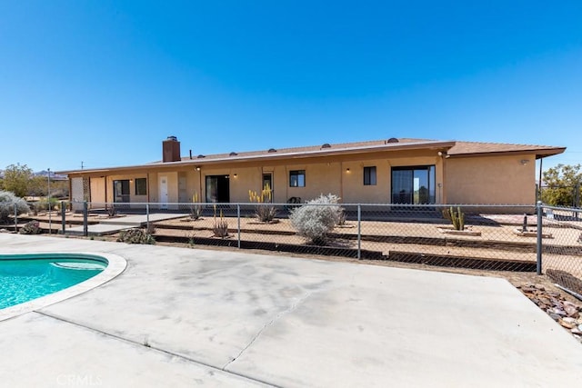 6425 Indian Cove Rd Unit 29, Palms, CA 92277 - back of house featuring a patio area, a chimney, and stucco siding