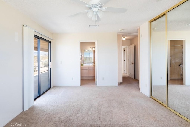 6425 Indian Cove Rd Unit 29, Palms, CA 92277 - unfurnished bedroom with carpet, access to exterior, connected bathroom, a closet, and a ceiling fan