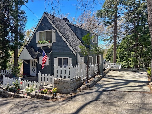 244 Manzanita Dr, Lake Arrowhead, CA 92352 - view of front facade featuring roof with shingles, a chimney, and a fenced front yard