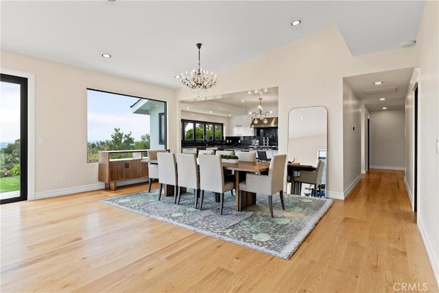 dining space with a chandelier, light wood-style flooring, recessed lighting, and baseboards