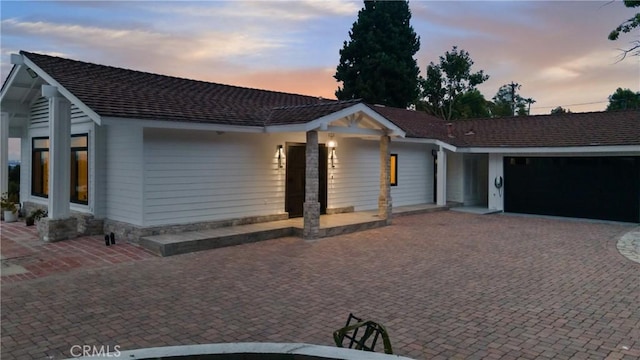 view of front facade featuring an attached garage and decorative driveway