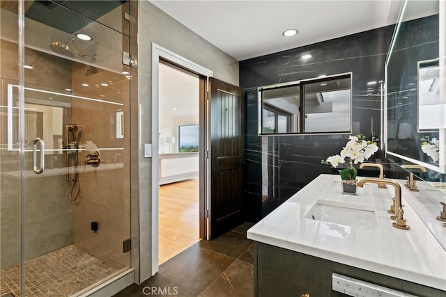 bathroom with a shower stall, double vanity, recessed lighting, and tile patterned flooring