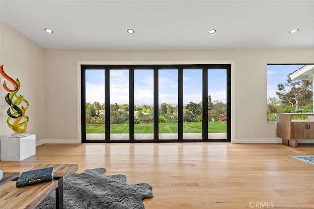 living room featuring baseboards, plenty of natural light, light wood finished floors, and recessed lighting