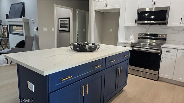 6485 Providence Ct, Magalia, CA 95954 - kitchen with appliances with stainless steel finishes, blue cabinetry, white cabinetry, and light wood-type flooring