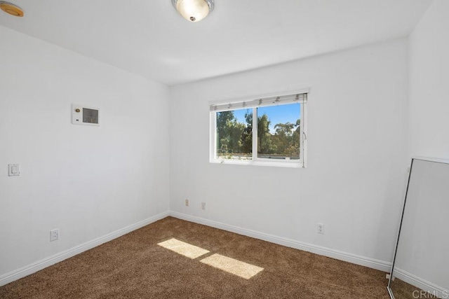 unfurnished room featuring carpet, baseboards, and a smoke detector
