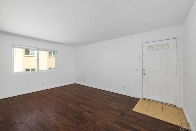 unfurnished room featuring wood finished floors and baseboards