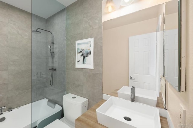 bathroom with toilet, tile walls, and vanity