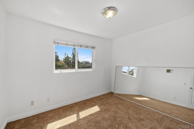 spare room featuring carpet floors and baseboards