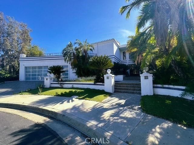 obstructed view of property featuring a fenced front yard, an attached garage, and stucco siding