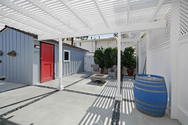 view of patio with a fire pit, a fenced backyard, a pergola, and an outbuilding