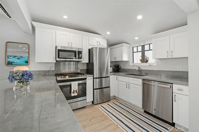 202 Onyx Ave, Newport Beach, CA 92662 - kitchen featuring appliances with stainless steel finishes, a sink, white cabinetry, light stone countertops, and recessed lighting