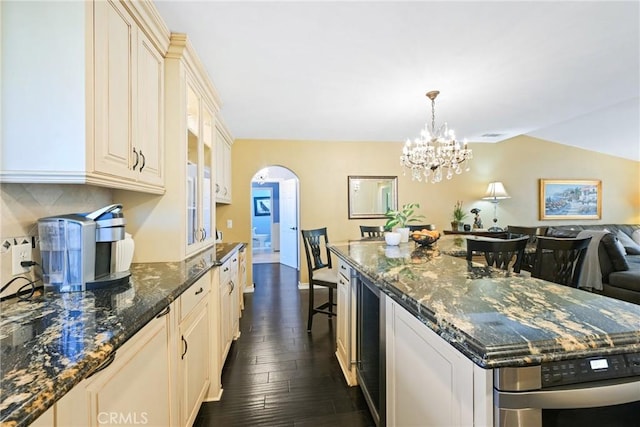 2018 Anaheim Ave, Costa Mesa, CA 92627 - kitchen with dark wood finished floors, cream cabinets, a chandelier, a spacious island, and dark stone countertops