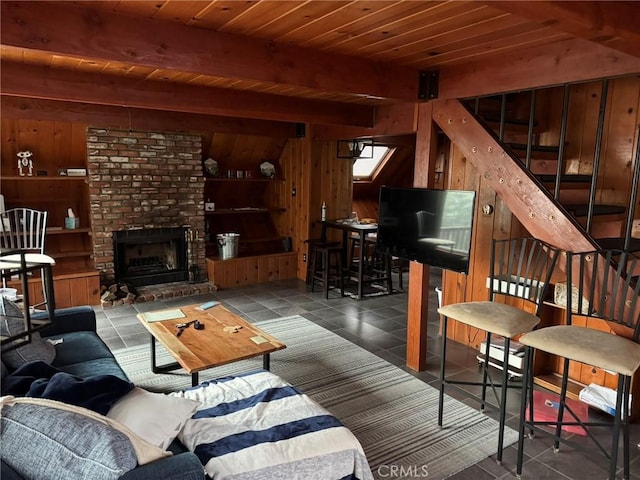 2548 Rim Of The World Dr, Running Springs, CA 92382 - tiled living area featuring wood walls, beam ceiling, stairs, a brick fireplace, and wooden ceiling