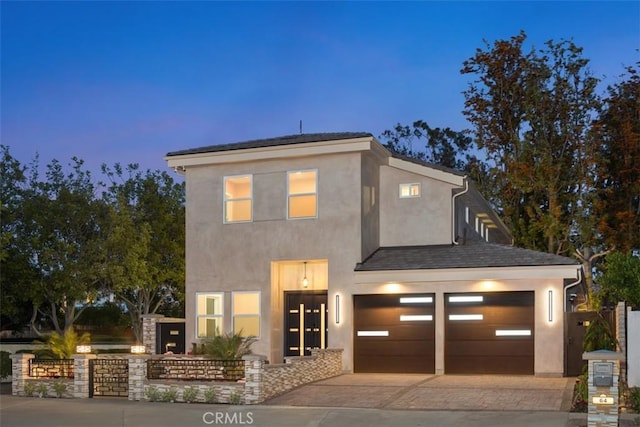 view of front facade with fence, stucco siding, and driveway